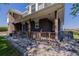 Close-up view of a covered front porch featuring brick columns and a cozy seating area at 14447 Madison St, Thornton, CO 80602
