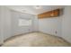 Empty room featuring tile flooring, storage cabinets and a window at 14447 Madison St, Thornton, CO 80602