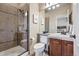 Tiled bathroom featuring glass enclosed shower, wooden vanity and a decorative mirror at 5192 Sedona Dr, Parker, CO 80134
