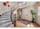 Elegant foyer features a curved staircase with iron railings, hardwood floors, and decorative wall art at 5192 Sedona Dr, Parker, CO 80134