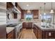 Spacious kitchen featuring stainless steel appliances, granite counters, custom cabinets, and a tile backsplash at 5192 Sedona Dr, Parker, CO 80134