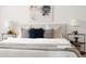Stylishly decorated bed featuring decorative pillows and lamps, with a bright white coverlet at 4500 E Louisiana Ave, Denver, CO 80246
