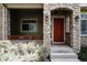 Charming front porch with a red door, stone accents, and manicured landscaping at 4500 E Louisiana Ave, Denver, CO 80246
