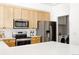 Contemporary kitchen boasting stainless steel appliances, light cabinets, and seamless access to the laundry room at 4500 E Louisiana Ave, Denver, CO 80246
