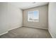 An empty bedroom showcasing a large window, neutral paint, and plush carpeting throughout at 9557 W San Juan Cir # 306, Littleton, CO 80128
