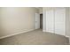 A carpeted bedroom with a closet and door leading to the other areas of the home at 9557 W San Juan Cir # 306, Littleton, CO 80128