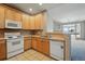 Cozy kitchen with wood cabinetry, modern appliances, and an inviting breakfast bar at 9557 W San Juan Cir # 306, Littleton, CO 80128