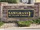 Attractive Sawgrass at Plum Creek community sign set in stone with manicured landscaping at 1368 Royal Troon Dr, Castle Rock, CO 80104