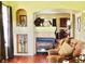 Cozy living room with a fireplace, display shelves, and a view to the kitchen at 1368 Royal Troon Dr, Castle Rock, CO 80104
