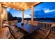 Cozy covered porch with outdoor seating. The lighting is provided by a spotlight and string lights overhead at 7965 S Titus Ct, Aurora, CO 80016