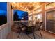 Well-lit covered back porch has a large table and chair set. The lighting is provided by string lights overhead at 7965 S Titus Ct, Aurora, CO 80016