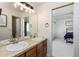 Bright bathroom vanity with double sinks and view into bedroom with natural light from the window at 7965 S Titus Ct, Aurora, CO 80016