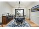 Dining room with large dark table, black chairs, modern light fixture, and large shuttered windows at 7965 S Titus Ct, Aurora, CO 80016