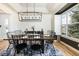 Dining room with large table, modern light fixture, and sideboard for serving at 7965 S Titus Ct, Aurora, CO 80016