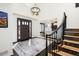 Grand entryway with dark wood door, staircase, chandelier, and view to living area with fireplace feature at 7965 S Titus Ct, Aurora, CO 80016