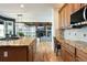 Kitchen with granite island, wooden cabinets, stainless steel microwave, and view to the fireplace feature at 7965 S Titus Ct, Aurora, CO 80016