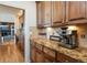 Kitchen nook with wooden cabinets, granite countertops, and view to the living room at 7965 S Titus Ct, Aurora, CO 80016