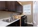 Functional laundry room with ample cabinet space, sink, folding surface, and appliances at 7965 S Titus Ct, Aurora, CO 80016