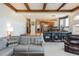 Bright living room with a stylish sectional sofa, decorative bookcase, and connecting kitchen and dining area at 7965 S Titus Ct, Aurora, CO 80016