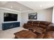 Relax in this living room, featuring a large leather sectional and a sleek entertainment center at 7965 S Titus Ct, Aurora, CO 80016