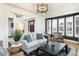 Open living room with shuttered windows, dark window frames, hardwood floors, and modern lighting at 7965 S Titus Ct, Aurora, CO 80016