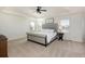 Spacious primary bedroom with neutral tones, carpet, ceiling fan and bright light from large shuttered windows at 7965 S Titus Ct, Aurora, CO 80016