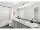 Bright bathroom with dual sinks, sleek fixtures, tiled shower, and decorative shelving at 4010 E 129Th Way, Thornton, CO 80241