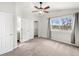 Bright bedroom with plush carpet, ceiling fan, and access to a closet and bathroom at 4010 E 129Th Way, Thornton, CO 80241