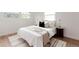 Bright bedroom with white bedding, accent pillows, and natural light from large windows at 1617 S Quitman St, Denver, CO 80219