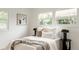 Bright bedroom with white bedding, accent pillows, and natural light from large windows at 1617 S Quitman St, Denver, CO 80219