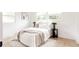 Bright bedroom with white bedding, accent pillows, and natural light from large windows at 1617 S Quitman St, Denver, CO 80219