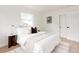 Bright bedroom with white bedding, accent pillows, and natural light from large windows at 1617 S Quitman St, Denver, CO 80219