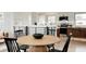 Open dining and kitchen area with wood floors and a modern wood table at 1617 S Quitman St, Denver, CO 80219
