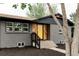 Attractive exterior view of a brick home, featuring updated windows, landscaping and a bright yellow front door at 1617 S Quitman St, Denver, CO 80219