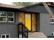 Stylish home exterior featuring a yellow front door with custom wood accents and gray brick at 1617 S Quitman St, Denver, CO 80219