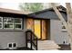 Charming brick home with a bright yellow front door and unique wood design at 1617 S Quitman St, Denver, CO 80219