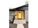 Close-up of a yellow front door with natural wood accents and gray brick exterior at 1617 S Quitman St, Denver, CO 80219