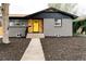 Charming home with a yellow front door, gray brick, and freshly mulched front yard at 1617 S Quitman St, Denver, CO 80219