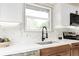 Modern kitchen with stainless steel appliances and tiled backsplash at 1617 S Quitman St, Denver, CO 80219