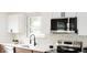 Modern kitchen with stainless steel appliances and tiled backsplash at 1617 S Quitman St, Denver, CO 80219