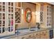 Stylish bar area with custom cabinets, a wine rack, a granite countertop, and a decorative mirror at 18971 Shadowood Dr, Monument, CO 80132