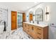 Modern bathroom with a double vanity, white countertop, wooden cabinetry, and marble tile flooring at 18971 Shadowood Dr, Monument, CO 80132
