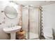 Bright bathroom features a modern pedestal sink, framed shower, and unique tile accent at 18971 Shadowood Dr, Monument, CO 80132