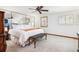 Bright main bedroom with a large bed, white bedding, a bench, and a window with plantation shutters at 18971 Shadowood Dr, Monument, CO 80132
