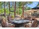 Inviting outdoor patio featuring a stone fire pit with seating nestled among tall trees and scenic views at 18971 Shadowood Dr, Monument, CO 80132