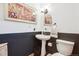 Elegant powder room featuring modern fixtures and a pedestal sink with a round mirror and decorative wall art at 18971 Shadowood Dr, Monument, CO 80132
