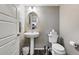 Powder room featuring a pedestal sink, toilet, and a decorative mirror at 6833 Longpark Dr, Parker, CO 80138
