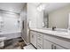 Bathroom featuring double sinks, white cabinetry, a shower-tub combo, and neutral-colored walls at 6833 Longpark Dr, Parker, CO 80138
