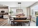 Dining room with a wooden table, bench seating, modern lighting, and views into the kitchen at 6833 Longpark Dr, Parker, CO 80138