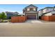 Exterior view of a two-story home with a two car garage and fenced yard at 6833 Longpark Dr, Parker, CO 80138
